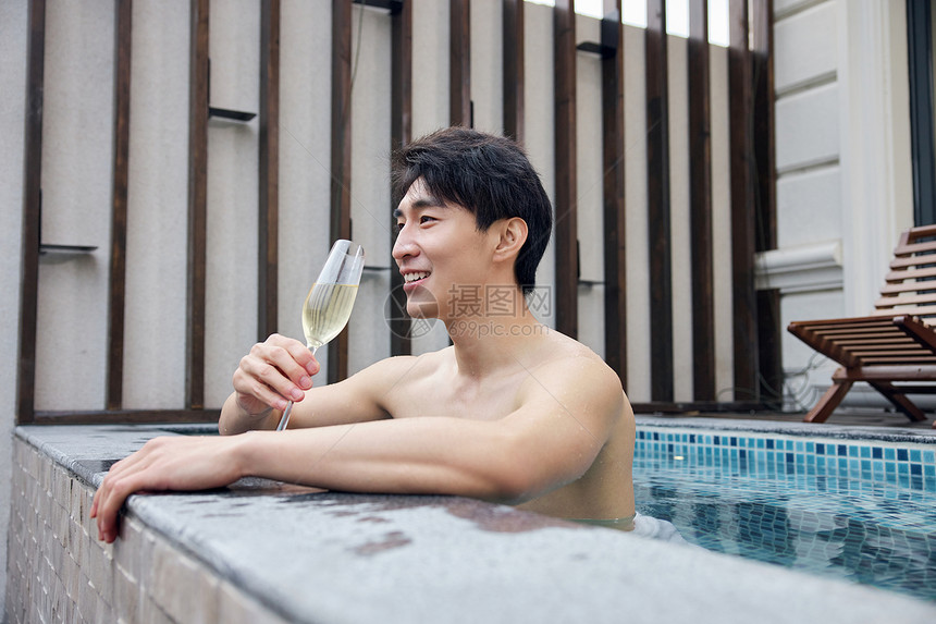 独自喝香槟泡温泉的青年男性图片