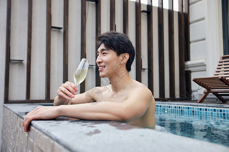 独自喝香槟泡温泉的青年男性图片