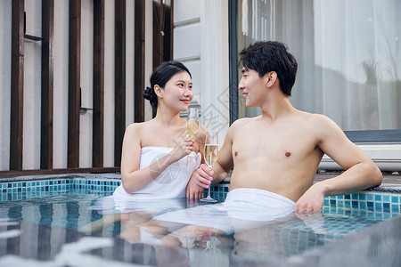 度假酒店泡温泉干杯的年轻情侣图片