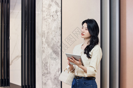平板电脑挑选大理石瓷砖的女性背景图片
