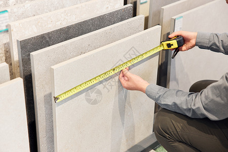 建材导购测量瓷砖面积特写图片