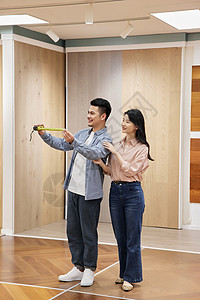 为新房挑选木地板的甜蜜夫妇形象高清图片