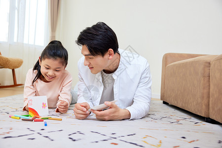 父女画素材父亲和女儿趴在地上画画背景