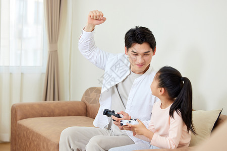 居家玩电子游戏的父女图片