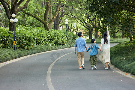 阳光下幸福一家人公园里散步背影背景