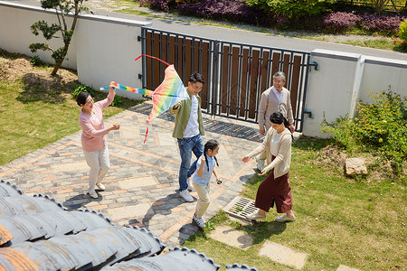 一家五口在院子里放风筝背景图片