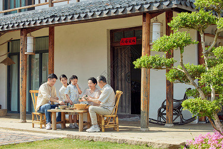 民俗游戏端午节坐在院子里包粽子的一家人背景