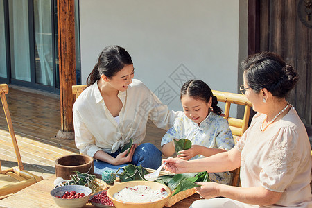 坐在粽子叶上祖孙三代在院子里包粽子背景