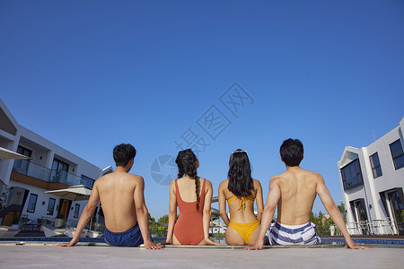 泳装年轻人们坐在泳池边背影图片