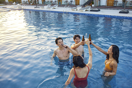 青年人夏日泳池喝酒干杯图片