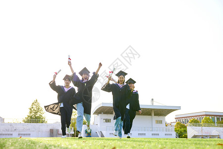 大学毕业生奔跑在草地上背景图片