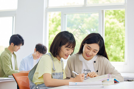 教室里的女大学生交流学习背景图片