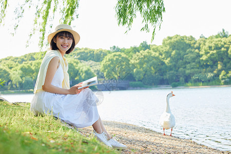 湖边散步夏日室外看书的女生背景