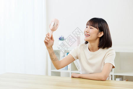 夏日风扇卡通夏日女生在家用风扇解暑背景