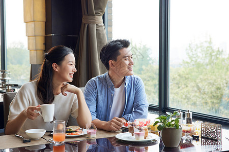 精致风景夫妻在餐厅用餐看窗外风景背景