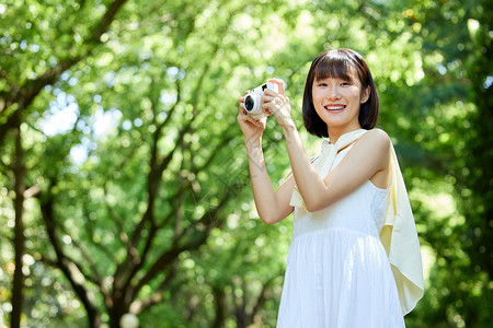 女性户外游玩举起照相机图片