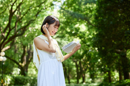 短发美女夏日学习夏日户外看书阅读的短发少女背景