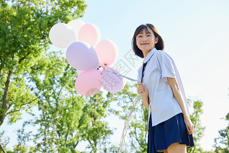 制服美女写真室外女学生手拿气球背景