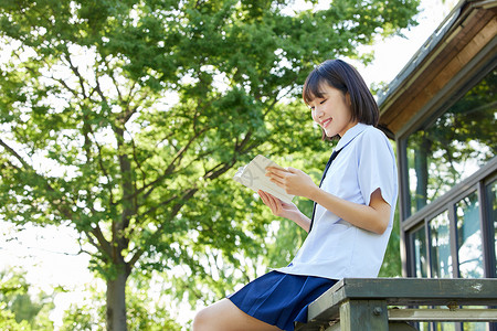 制服美女写真阳光下看书的女学生背景