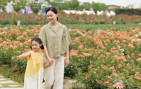 小孩子看远方母女一起在公园看玫瑰花背景