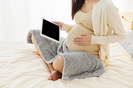 居家养胎的孕妇看pad特写背景