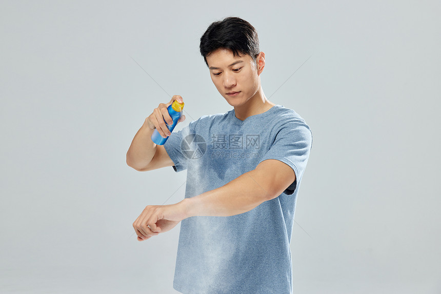 男青年手臂喷洒防晒霜图片