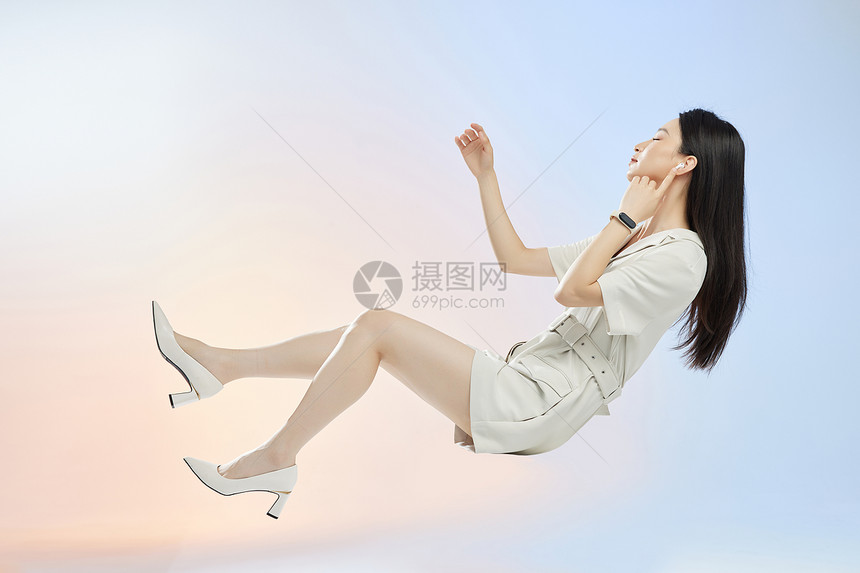佩戴电子设备的女人悬浮在空中听音乐图片