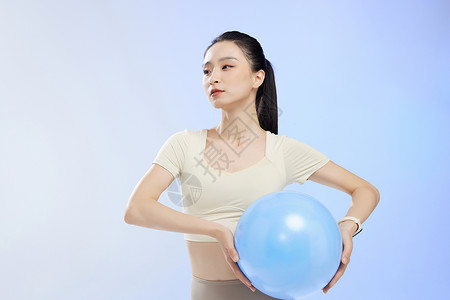 运动少女佩戴电子手表锻炼瑜伽球高清图片