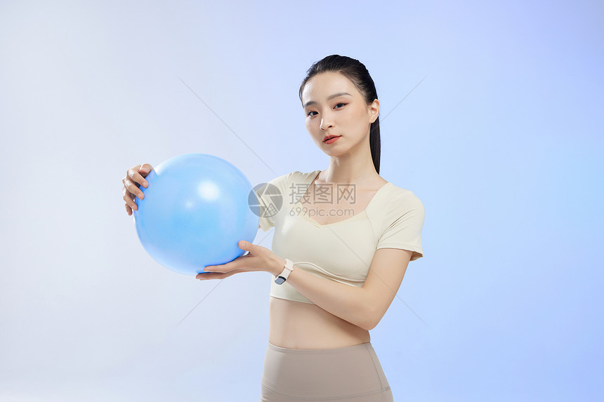 运动少女手拿瑜伽球形象图片