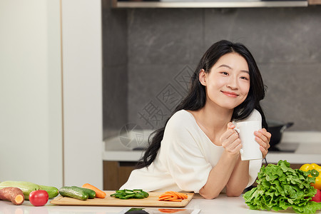 饮品柜女性手捧饮品靠在餐桌边形象背景