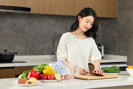 女人将案板上的肉放到破壁机里高清图片