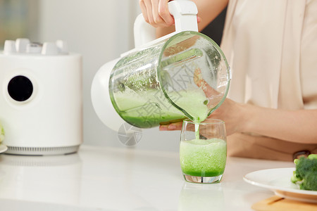 电子绿色将榨汁机的果汁倒出特写背景