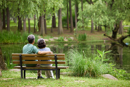 湖畔生活老夫妻坐在湖畔边长凳上背景