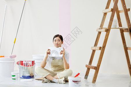 女子盘坐着构思房屋设计背景图片