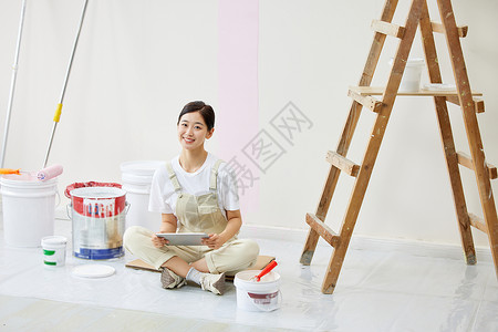 粉色背景墙女子盘坐着构思房屋装修设计背景