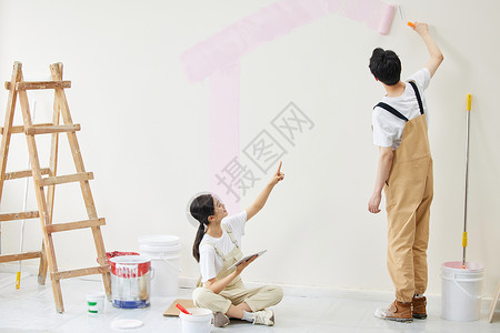 粉色油漆滴落情侣合力粉刷墙壁背景