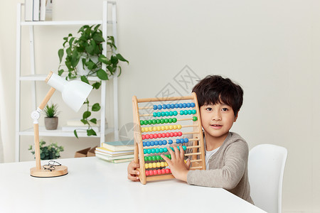 书桌上玩智力玩具的男孩高清图片