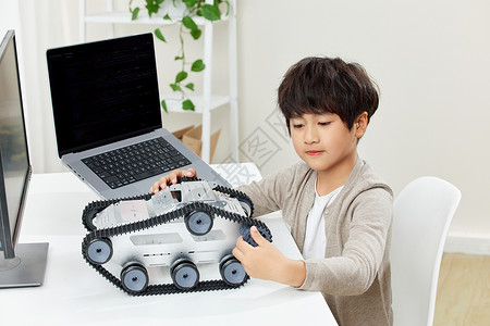 电脑桌前研究科技设备的小男孩背景图片