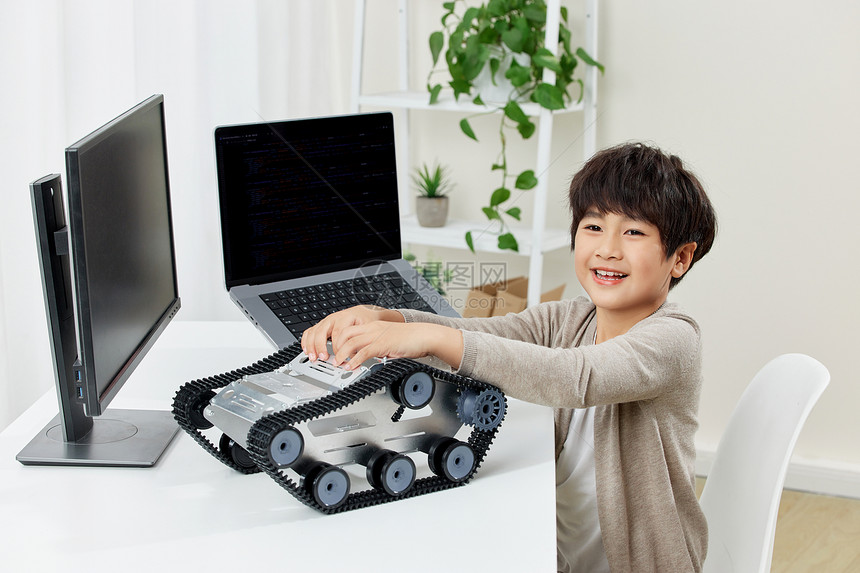 电脑桌前研究机器设备的男孩图片