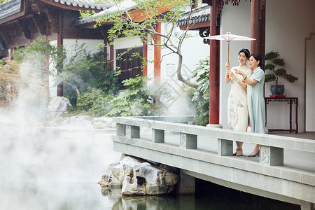 穿旗袍的母女欣赏中式庭院雨中美景图片