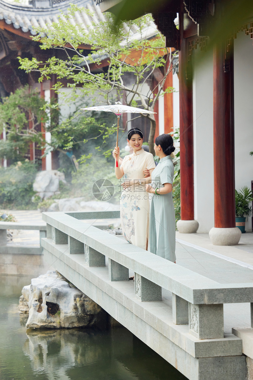 下雨天在中式庭院撑伞的旗袍母女图片