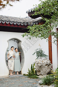 江南梅雨雨天穿旗袍的女性欣赏庭院美景背景