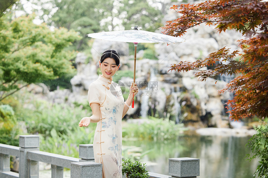 雨天撑伞在中式庭院中的旗袍女性图片