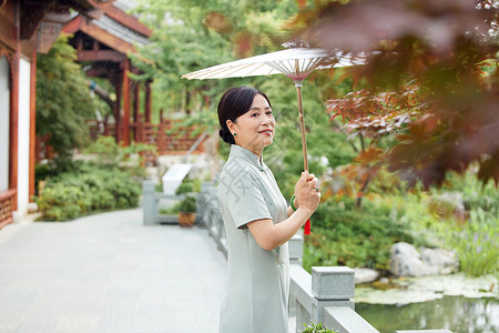 户外撑伞的中年女性图片