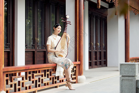 旗袍女性户外弹奏琵琶背景图片