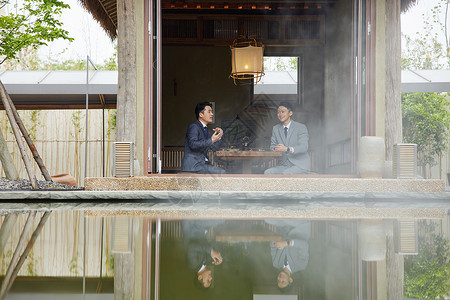 湖边喝茶商务人士在湖中小亭品茶背景