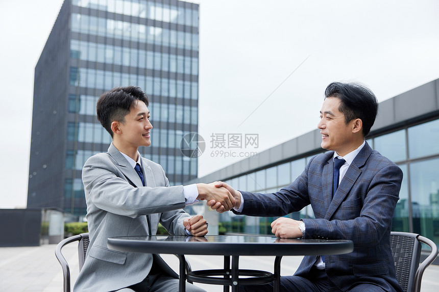 洽谈合作后握手的男人们图片