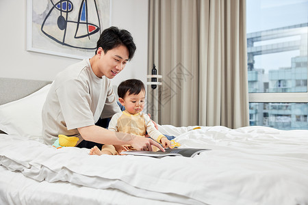 卧室里年轻父亲陪宝宝玩耍图片