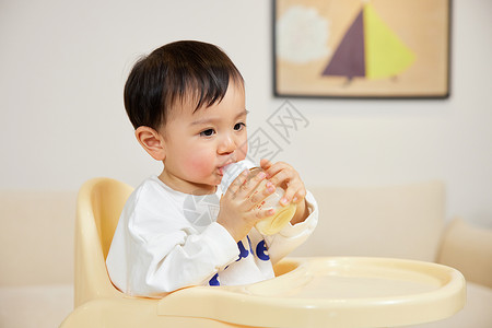 小宝宝坐在椅子上喝奶图片