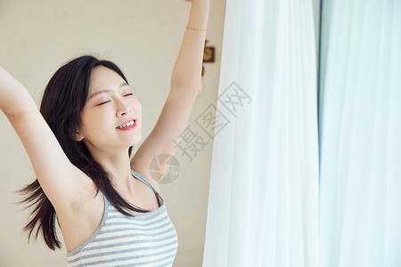 早上起床窗边伸懒腰的女性高清图片
